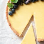 close up of a lemon tart with a slice missing