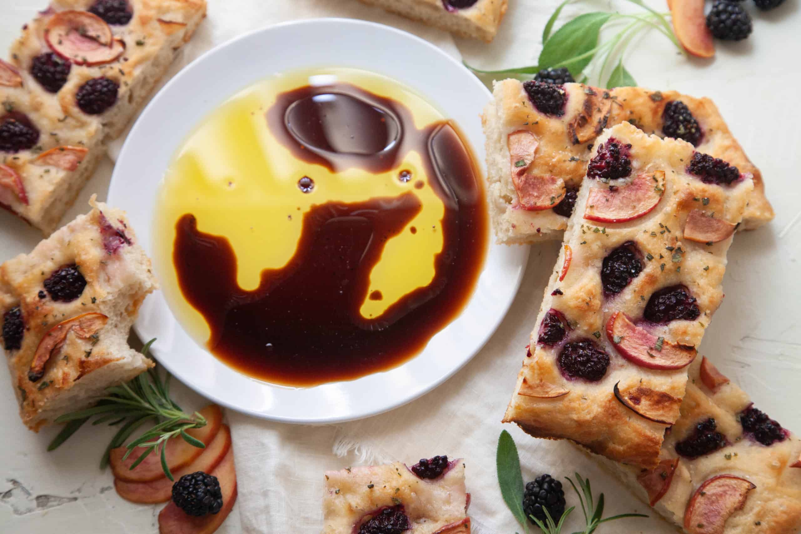 pieces of blackberry foccacia surrounding olive oil and balsamic