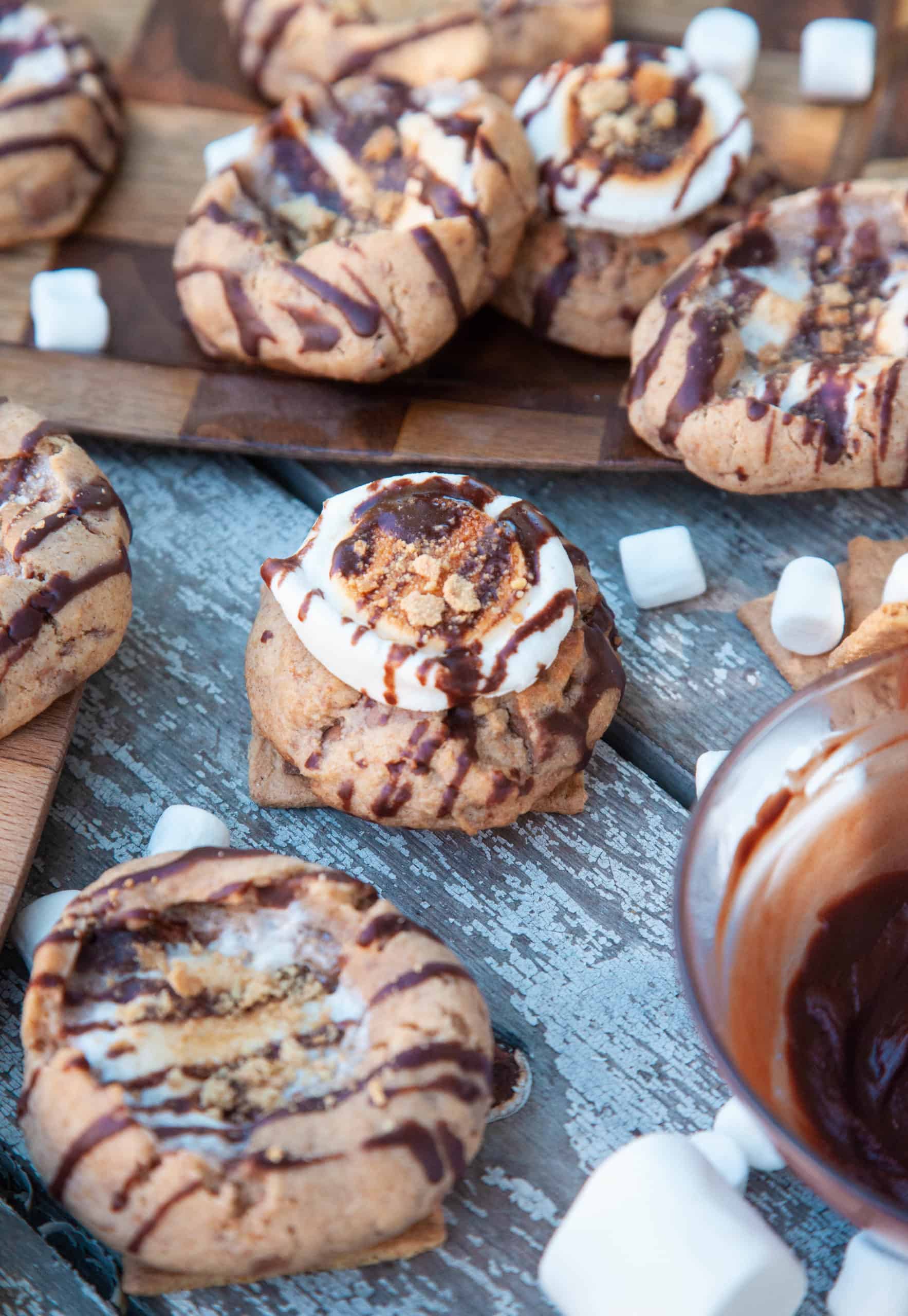 s'mores cookies on a picnic table with marshmallows and chocolate
