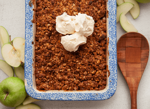 apple crumble with vanilla ice cream surrounded by Granny Smith apples